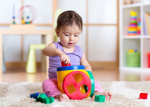 תינוקת משחקת בצעצועי התפתחות לתינוק